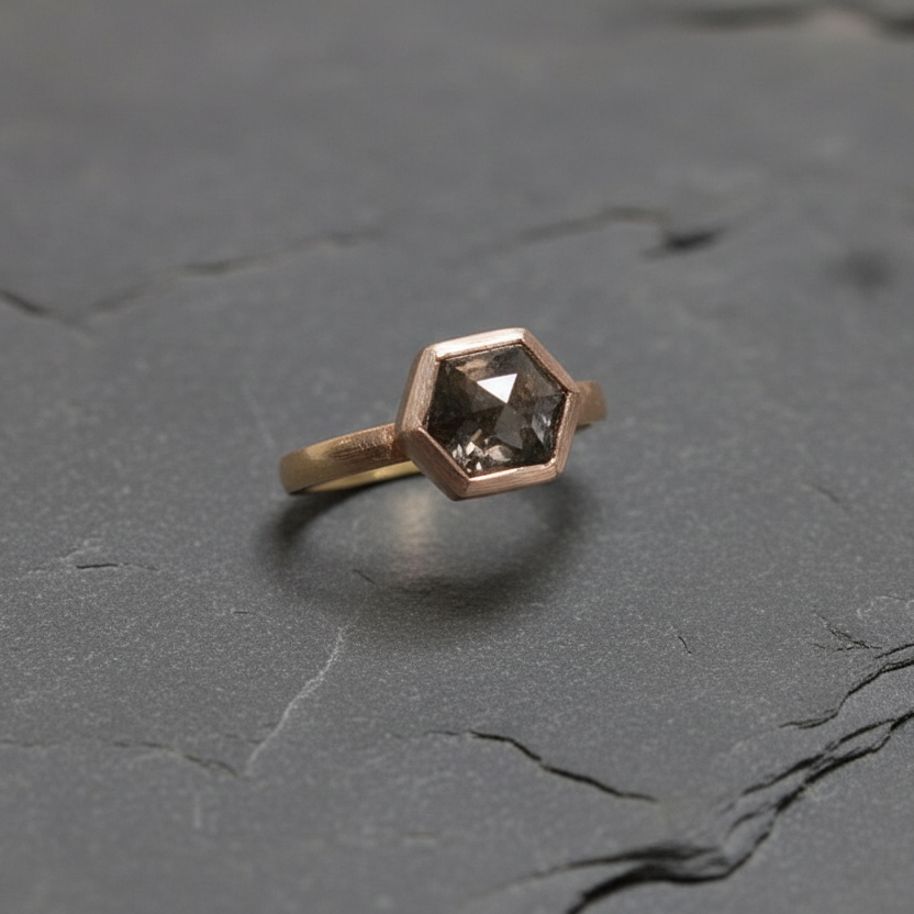 Hexagonal diamond ring on a dark stone surface