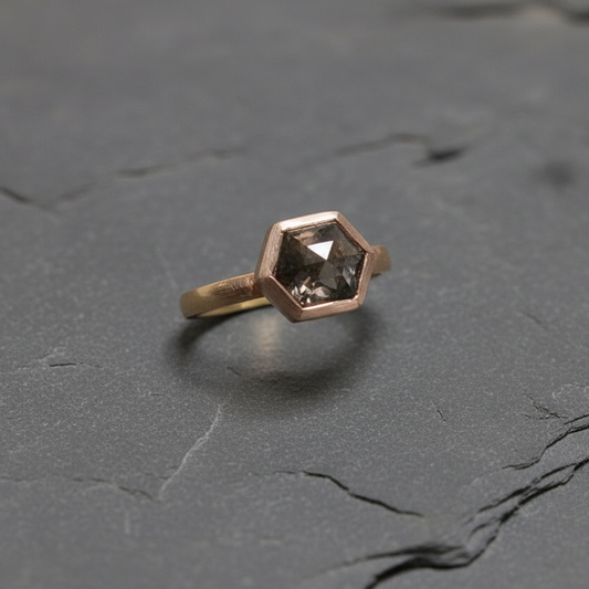 Hexagonal diamond ring on a dark stone surface